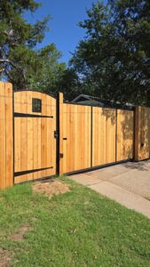 A wood fence with a decorative metal gate installed by ProScape Outdoor Construction LLC in Norman, OK.