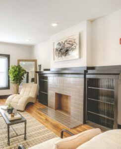 A living room showcasing new wood flooring and a beautifully tiled fireplace by Keystone Carpet & Tile in Omaha, NE.
