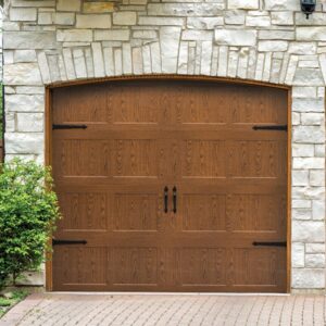 A beautiful wood-grain garage door with decorative hardware under a stone arch by American Overhead Door in Madison, AL