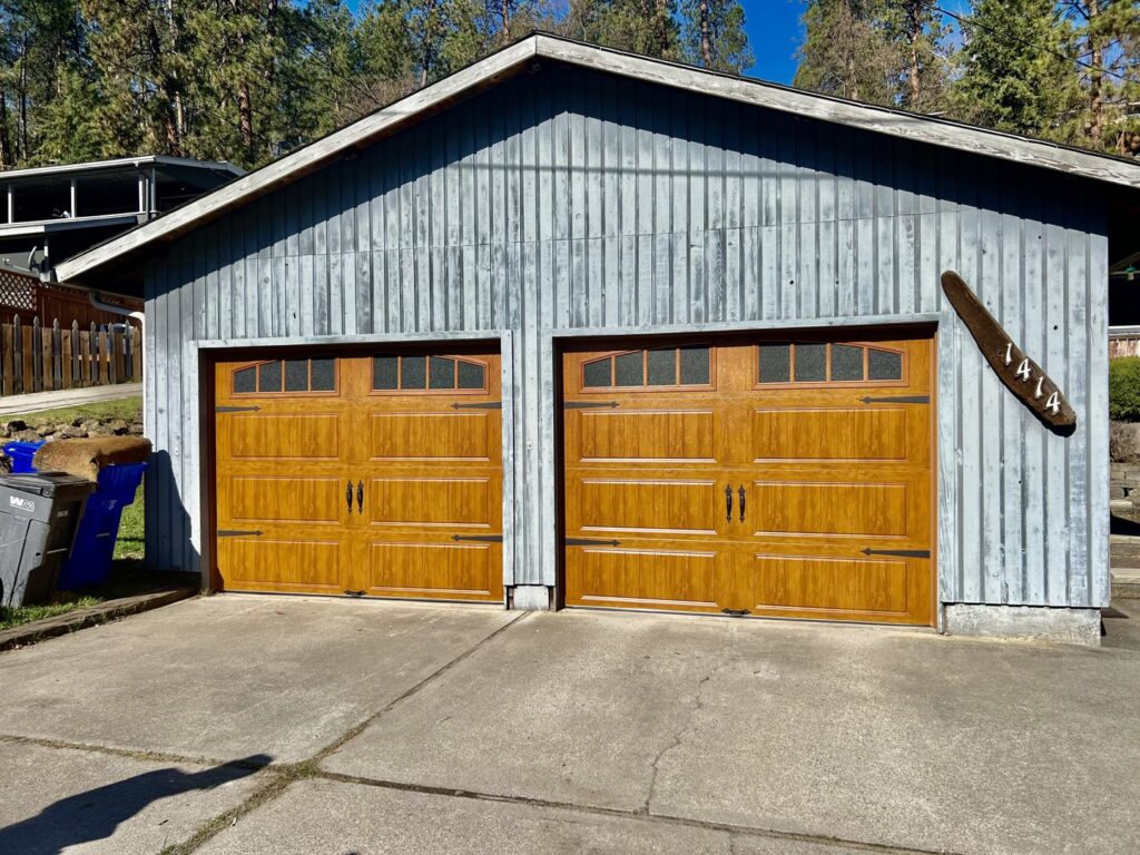 New wood-grain panel garage doors with windows on a home, installed by Continental Door Company in Spokane Valley, WA.