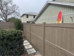 A durable wood-look composite fence installed around a residential property by Gaines Fence in Jacksonville, FL.