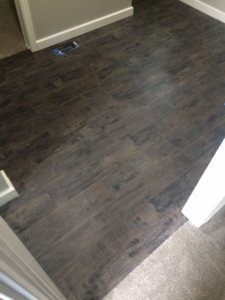 A clean transition from dark wood-look flooring to carpet, installed by All Dimension Floor Care in Lenexa, KS.