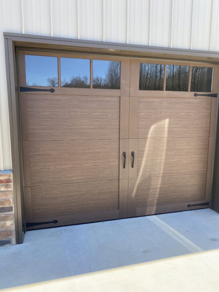 A brown wood-look garage door with top windows and decorative hardware installed by Smith's Garage Door in Clarksville, TN.