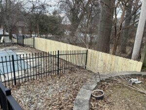 A combination wood privacy and black metal ornamental fence by Sexton Property Services STL in High Ridge, MO.