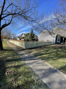 A newly installed wood picket fence running along a sidewalk and front yard by GoldHammer in Sebastopol, CA.