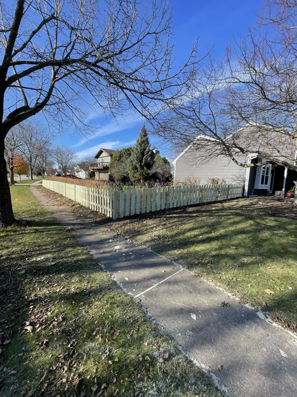 A newly installed wood picket fence running along a sidewalk and front yard by GoldHammer in Sebastopol, CA.