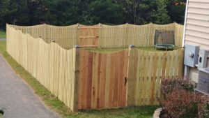 A wooden picket fence with a gate enclosing a backyard, installed by Universal Fence LLC in Drainesville, VA.