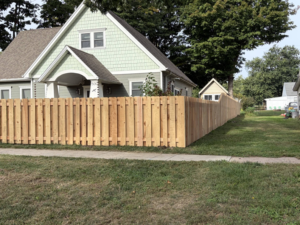 A newly installed wood picket fence along the front yard of a house by Walker Fence in Council Bluffs, IA.
