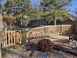 A new wood picket fence with a gate installed in a backyard by Barney's Landscaping in Dayton, OH.
