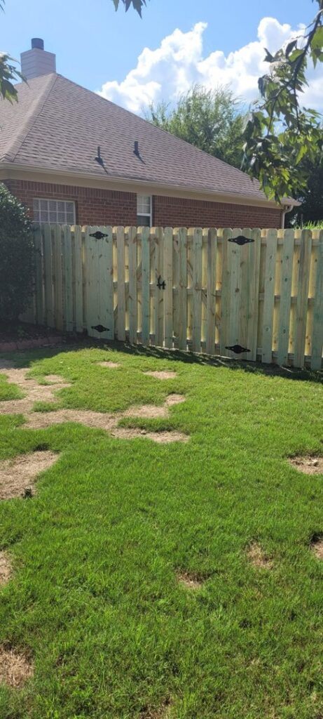 A classic wood picket fence with a functional gate, expertly installed by The Fence Dudes in Birmingham, AL.