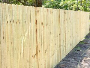 A newly constructed wood picket privacy fence for a residential property by Boost My Home in St. Augustine, FL.