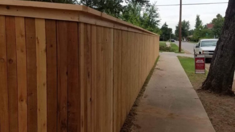 A tall wooden privacy fence installed along a residential sidewalk by 12 Corners Fence Company in Tecumseh, OK
