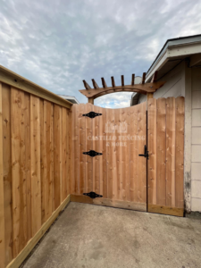 A custom wood privacy fence and gate with an arched top by Castillo Fencing & More in Corpus Christi, TX.