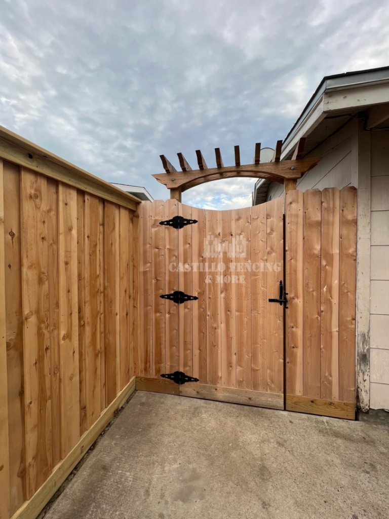 A custom wood privacy fence and gate with an arched top by Castillo Fencing & More in Corpus Christi, TX.