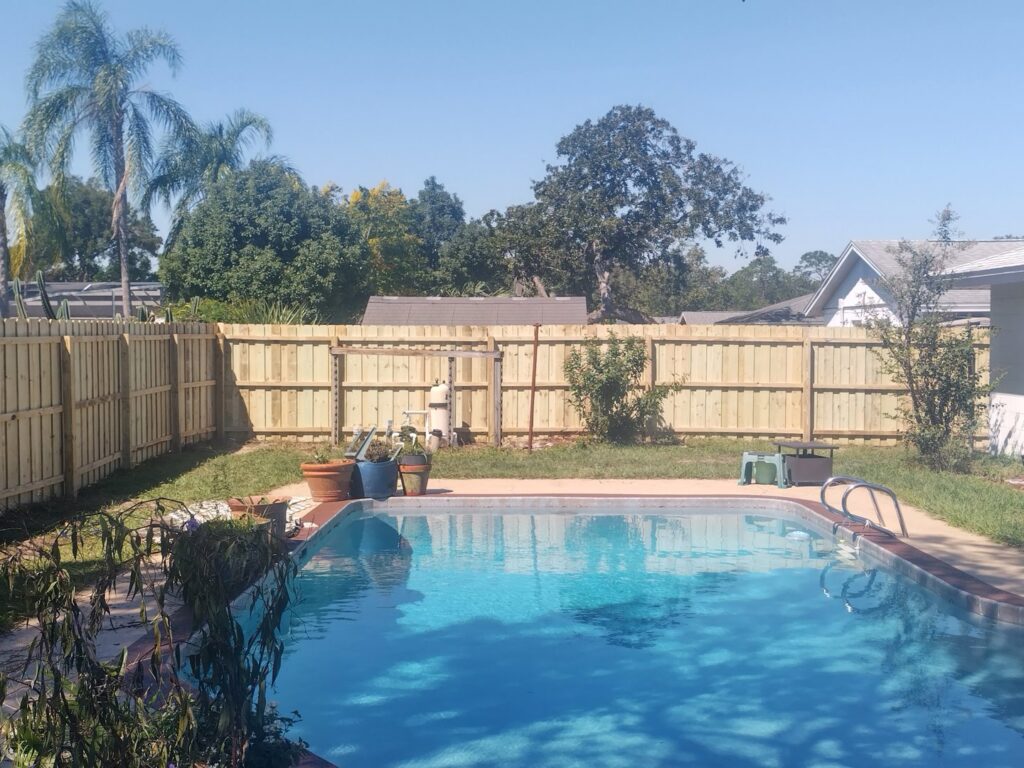 A newly installed wood privacy fence surrounding a residential pool area by Florida Professional Fence LLC in Altamonte Springs, FL.