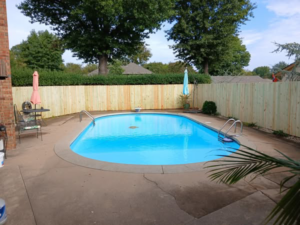 A new wooden privacy fence installed around a swimming pool by Master Fence Builders in Fort Smith, AR.