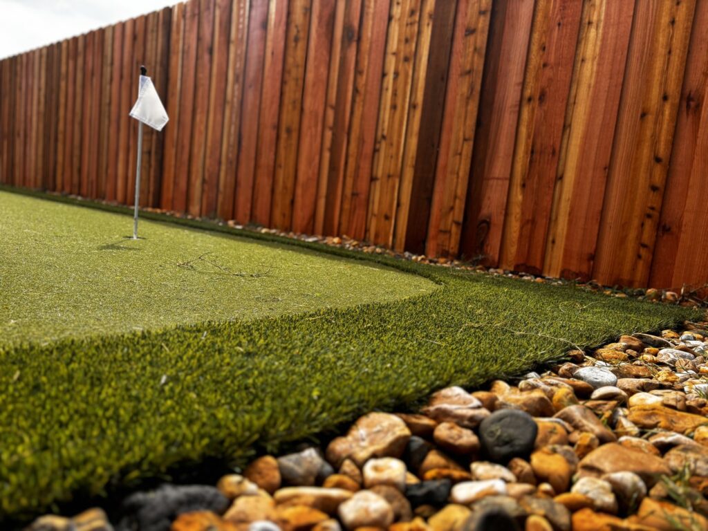 A new wood privacy fence installed around a putting green by Lynch's Lawn & Fence LLC in Bossier City, LA.