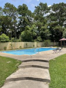 A wooden privacy fence installed around a swimming pool area by Jaguar Fence LLC in Mobile, AL.