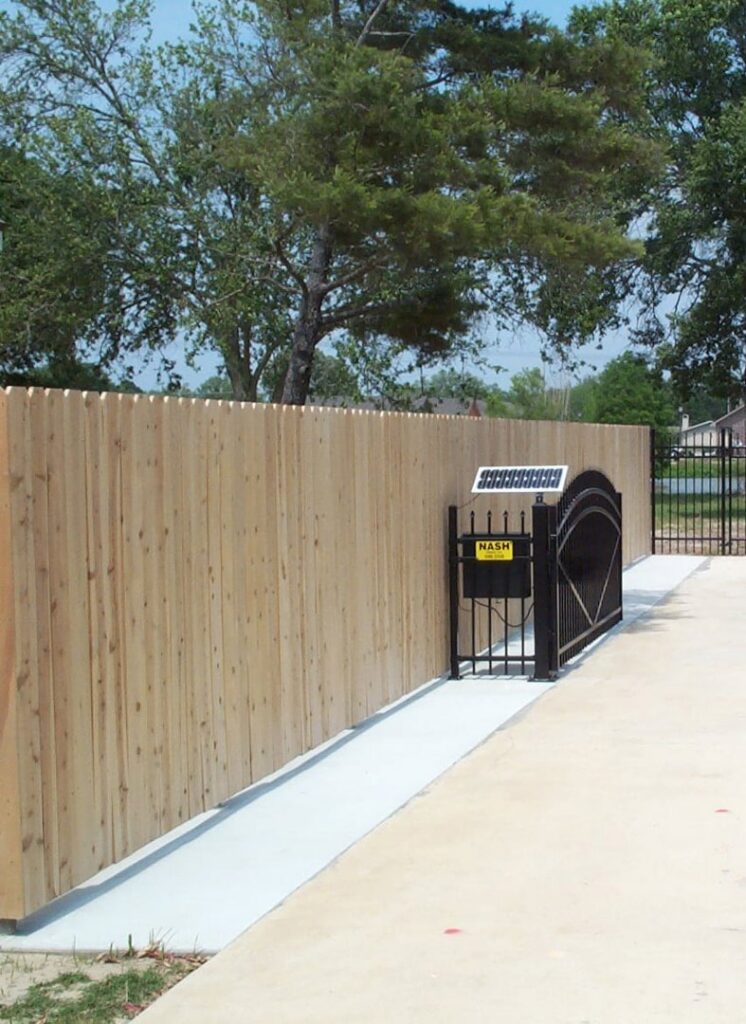 A wooden privacy fence with an automated gate system installed by Nash Fence & Supplies Inc. in Lake Charles, LA.