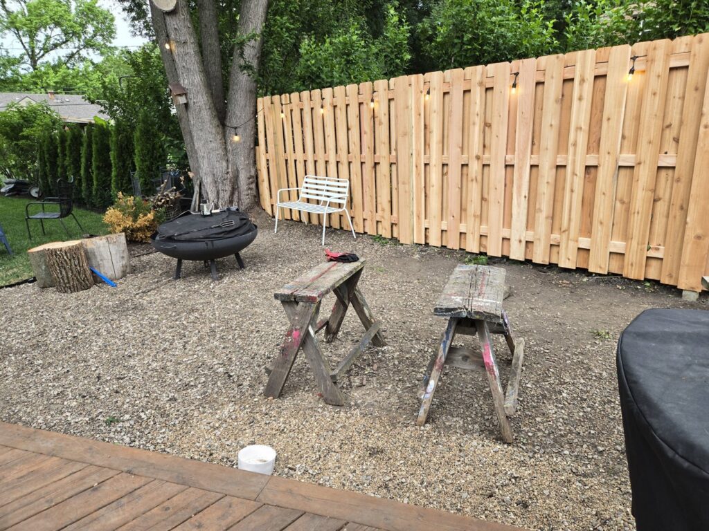 A newly installed wood privacy fence in a backyard with tools nearby by Pride Fence in Peabody, MA.