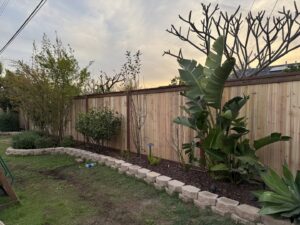 A newly installed natural wood privacy fence enhancing a backyard with lush landscaping by True American Fence Supply and Construction in Anaheim, CA.