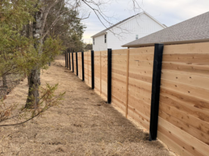 A new wood privacy fence with black metal posts installed by Old School Fence Co. in Springfield, MO.