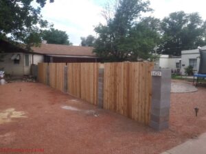A wood privacy fence with decorative concrete block posts by Stewart & Son Gate & Fence Co. in Hillsboro, OR