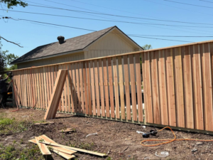 A wooden privacy fence under construction with boards and tools on the ground by True Ways Services LLC in Mesquite, TX.