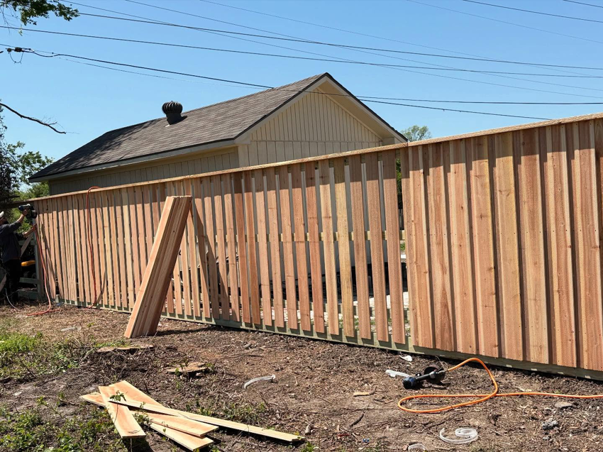 A wooden privacy fence under construction with boards and tools on the ground by True Ways Services LLC in Mesquite, TX.