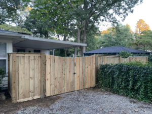 A natural wood privacy fence with a double gate installed by Brock Brothers Fence for a home in Mobile, AL.