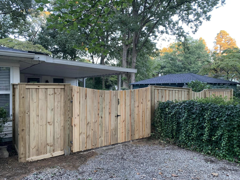 A natural wood privacy fence with a double gate installed by Brock Brothers Fence for a home in Mobile, AL.