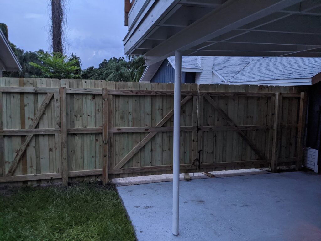 A newly installed wood privacy fence with a double gate, completed by Fencing & Railing 2 Corp in Orlando, FL.