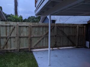 A newly installed wood privacy fence with a double gate, completed by Fencing & Railing 2 Corp in Orlando, FL.