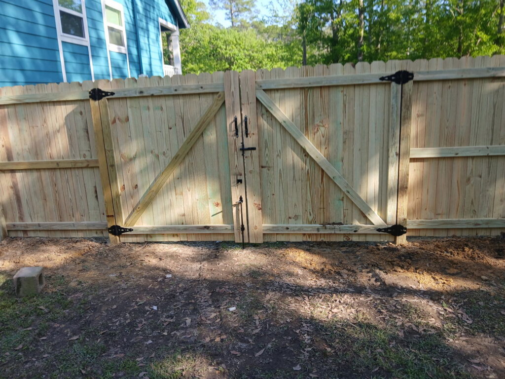 A newly installed wood privacy fence with a double gate, completed by FenceCo LLC in Pass Christian, MS.