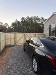 A newly installed wood privacy fence with a double gate for a residential property by FenceCo LLC in Pass Christian, MS.