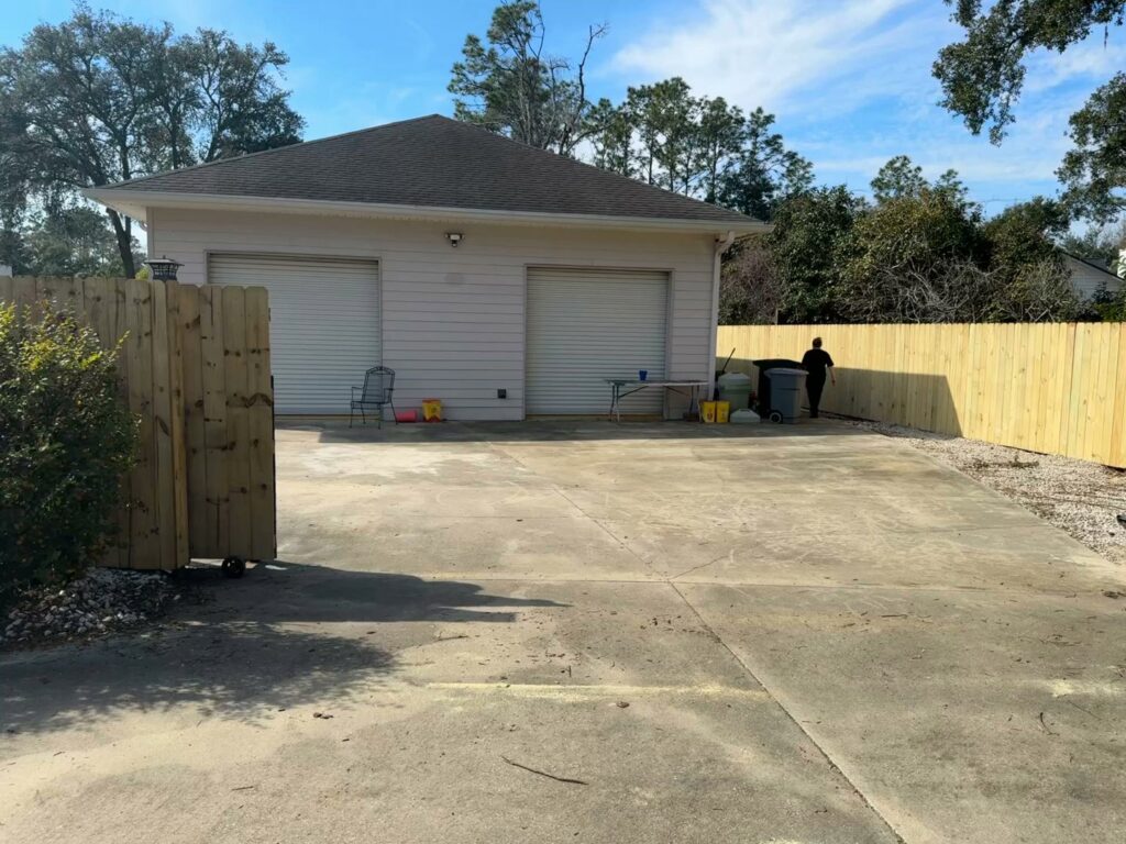 A newly installed wood privacy fence bordering a driveway and garage by Fence Nation LLC in Jacksonville, FL.