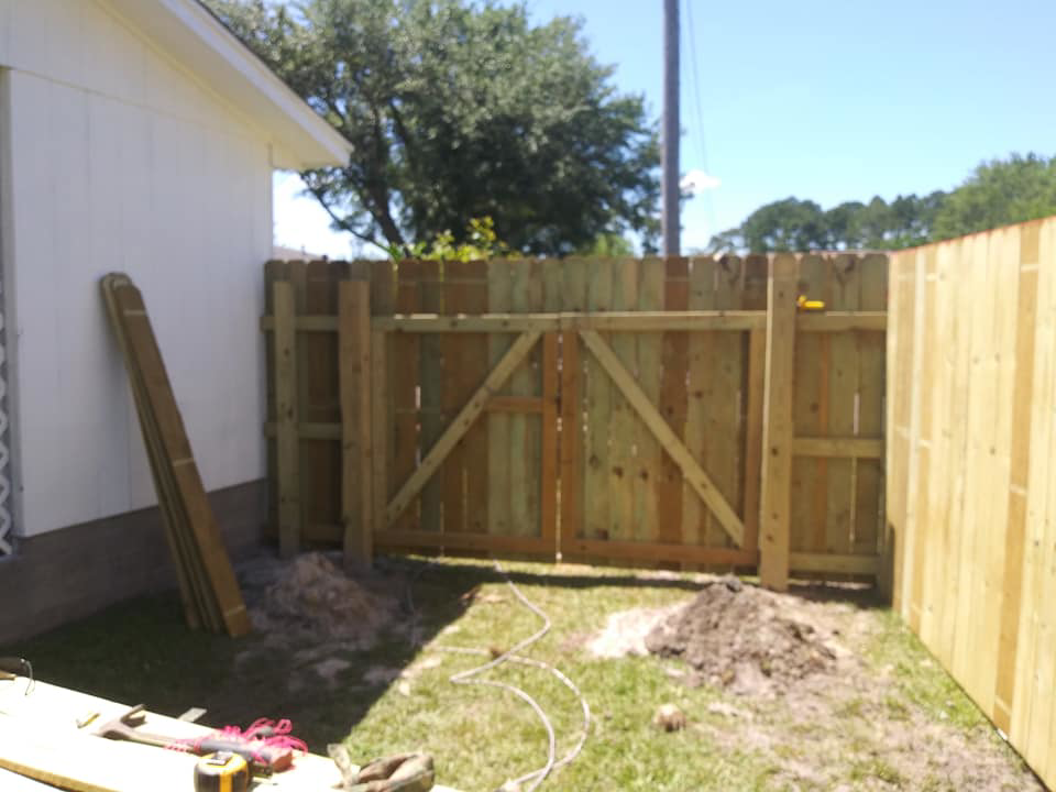 A wood privacy fence and double gate under construction, showing the installation process by Country Boyz fencing in Biloxi, MS.