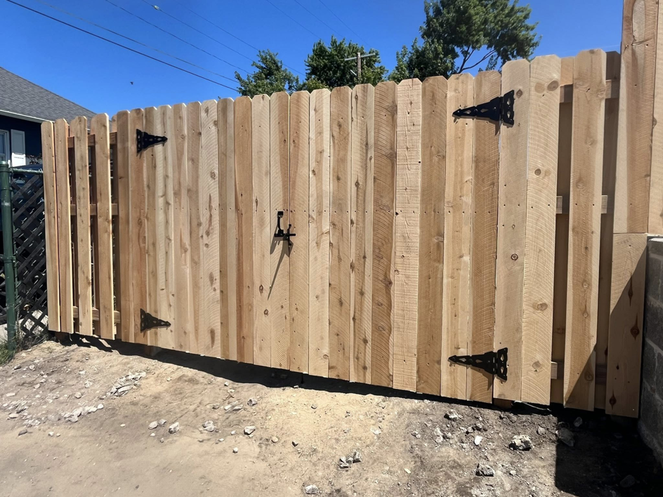 A newly installed wood privacy fence gate with black hardware by Final Touch Fencing LLC in Macomb Township, MI.