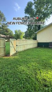 A newly installed wood privacy fence with a gate by Hawk Fences LLC in Johns Creek, GA, providing backyard security.