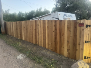 A newly installed wood privacy fence with a gate by HG Fencing LLC in Fountain, CO.