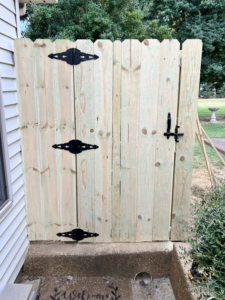 A newly installed wood privacy fence gate with black hardware by Rice&Family Fencing LLC in Greenfield, TN.