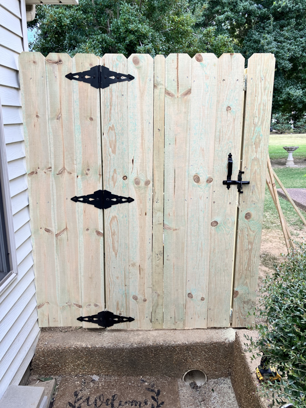 A newly installed wood privacy fence gate with black hardware by Rice&Family Fencing LLC in Greenfield, TN.