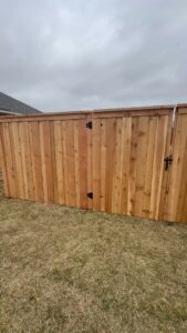 A wood privacy fence with a matching gate installed by Liberty Fence & Stain in San Antonio, TX.