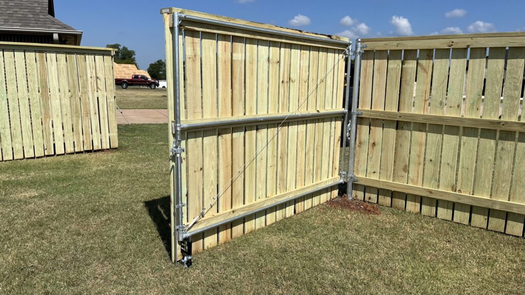 A sturdy wooden privacy fence gate with a metal frame, installed by 12 Corners Fence Company in Tecumseh, OK
