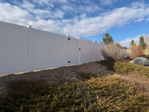 A newly installed wood privacy fence with a gate, featuring black hardware, by Supreme Fencing Denver, CO.