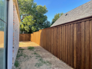 A newly installed wood privacy fence in a residential side yard by 3M Custom Fence in Lewisville, TX.
