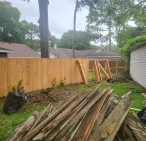 A new wood privacy fence under construction with old fence debris, demonstrating a job by Discount Fence Supply in Great Falls, SC.