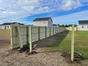 A long wood privacy fence installation in progress for a new development by STILL Fencing in Rochester, NY.