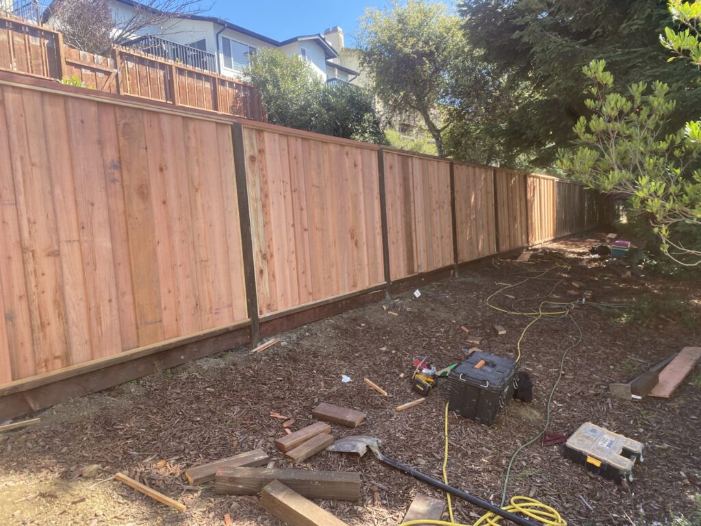 A wood privacy fence installation in progress with tools and materials on the ground by Superior Fence & Rail in San Jose, CA.