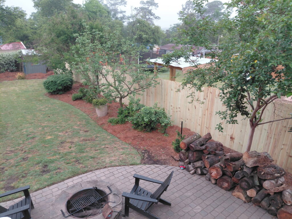 A wood privacy fence installed in a beautifully landscaped backyard by CSRA Solutions in Jackson, SC.